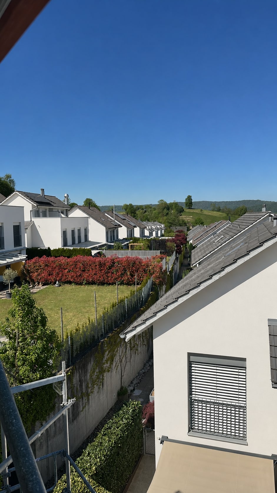 Blick vom Gerüst auf helle Hausfassaden und Gärten in einem Wohnquartier